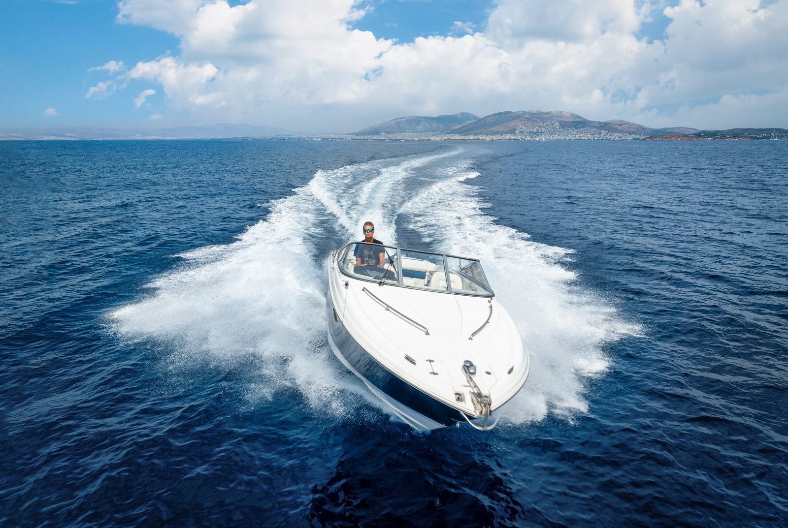 Aerial front view of a speedboat cruising over the sea during sunset time with copy space location bateaux